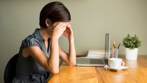 lady has Hashimoto's sitting on the table with a cup of coffee and laptop